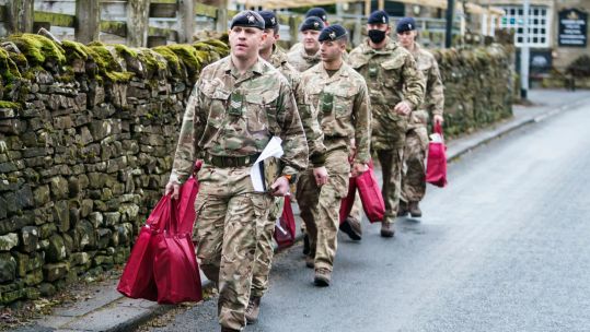 Members of the Armed Forces carry care packs in Weardale, County Durham, to hand to residents who have been without power for a week since Storm Arwen 031221 CREDIT PA, ALAMY