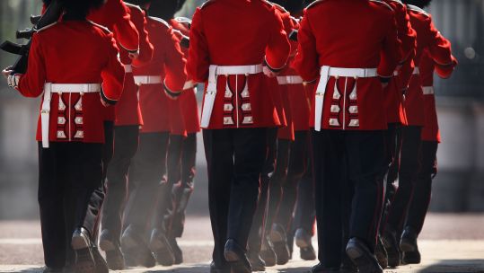 Members of the Scots Guards kick up dust during the Changing of the Guard ceremony at Buckingham Palace in London