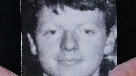 Cover image: Michael McElhone holds a photograph of his brother Paddy McElhone, outside Omagh courthouse (Picture: PA).