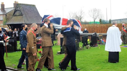 Military pallbearers carry a coffin containing the ashes of 119 reinterred veterans