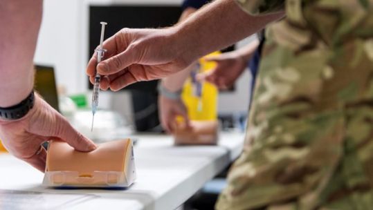 Military personnel practice vaccination procedures by injecting a simulated arm, under the instruction of an NHS staff nurse at Ashton Gate, Bristol (Picture: MOD).