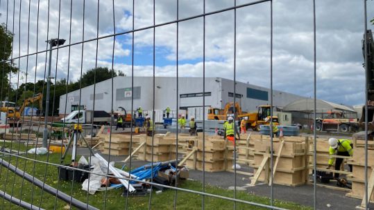 NHS Nightingale Hospital Exeter under construction as seen from behind fence.
