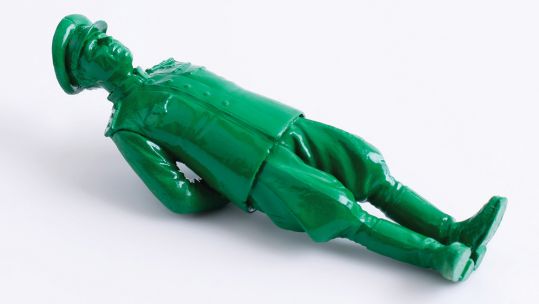 Green model or toy soldier lying on the ground