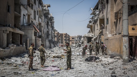 Soldiers of the Syrian Democratic Forces (SDF) move through debris at the front line in the Al Dariya neighborhood in western Raqqa
