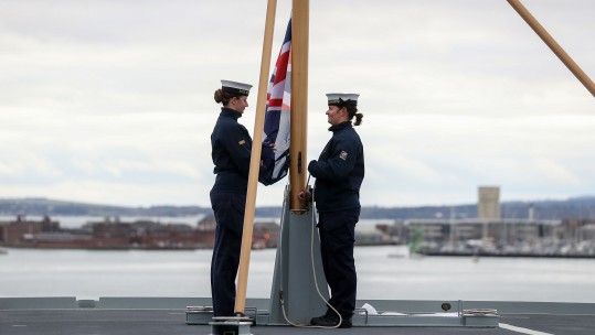 Royal Navy ratings Able Seaman Ellie Smith (left) and Able Seaman Jessica Hewes practice raising the Ensign on the flight deck of HMS Queen Elizabeth ahead of her commissioning ceremony on Thursday in Portsmouth