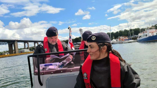 PC Warnock consults a textbook while delivering training, 110124 CREDIT Royal Navy