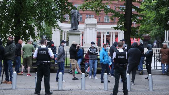 People outside City Hall in Belfast in Northern Ireland to the protect war memorials in its grounds (Picture: PA).