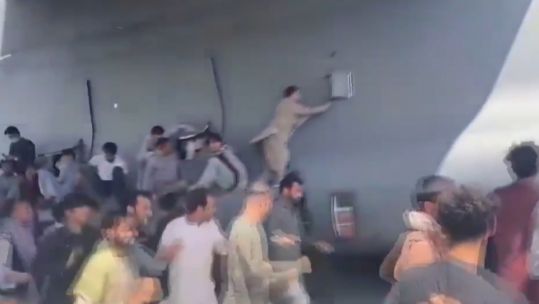People thought to be clinging to a US Air Force plane as it leaves Kabul airport close up