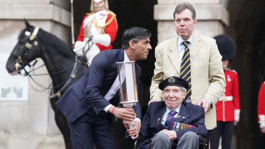 Rishi Sunak hands the Commonwealth War Graves Commission's Torch of Commemoration to Royal Navy D-Day veteran Peter Kent (Picture: PA)