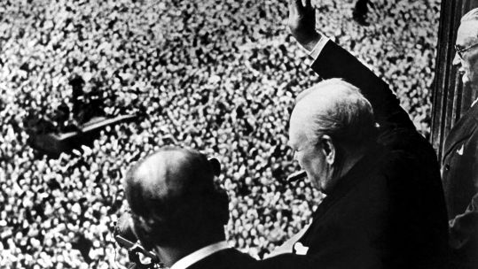 Prime Minister Winston Churchill gives his famous V for Victory sign to a crowd of 50,000 from balcony of Ministry of Health on VE Day