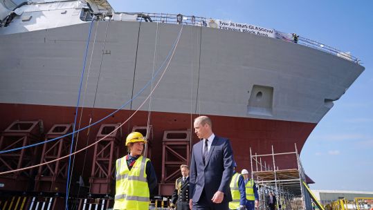 Prince William Duke of Cambridge with apprentice Cara Shannon at BAE Systems in Glasgow with Type 26 HMS Glasgow behind 290621 CREDIT PA ALAMY.jpg