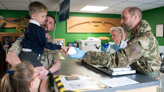 Prince William hands out breakfast rolls during visit to Army Air Corps