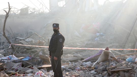 Rescue workers clear out the ruins of a residential house as they search for survivors after a military strike in Ganza Azerbaijan (Picture: PA).