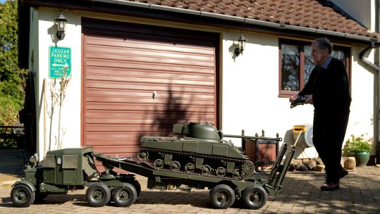 Roland Hopper in his garden near Saffron Walden, Essex, with his 8ft remote control model tank and model tank transporter lorry, 040423 CREDIT PA NOT FOR REUSE
