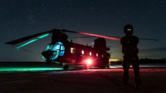 A Royal Air Force CH-47 Chinook helicopter rests at night during a training mission in the Arizona desert. The chinook was being used at a FARP to refuel USMC helicopters (Picture: RAF).