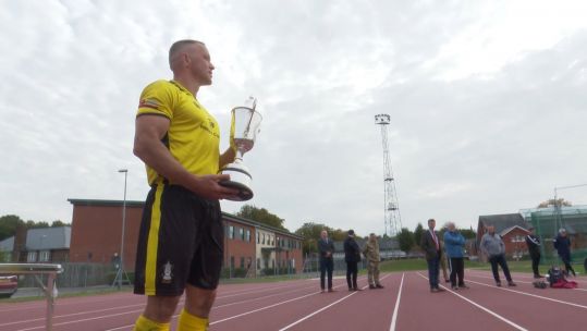Royal Engineers captain Corporal Craig Stevenson holding the Woolwich Cup after his team beat the Royal Signals 2-1 