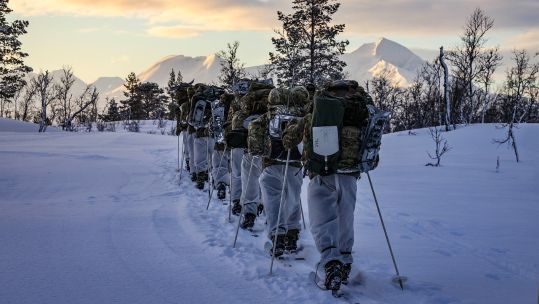 Royal Marines Commandos use skis and carry bergens as they move across country during cold weather training in Norway