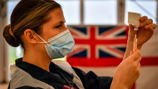 Cover image: Royal Navy service member prepares to give a coronavirus vaccine (Picture: PA).