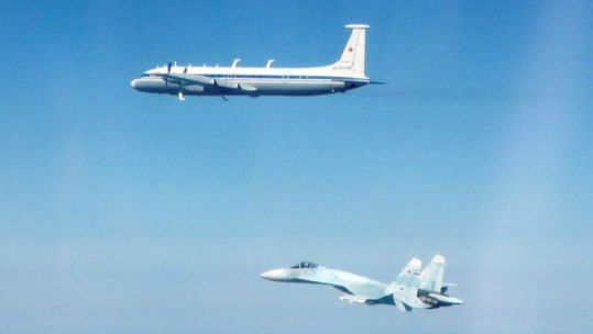 Russian Ilyushin Il-22 Bizon and a SU-27 Flanker aircraft, flying along the Baltic coast