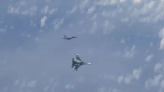 Russian SU-27 wards off NATO F-18 after it flies too close to the Rissian minister's plane 150819 CREDIT Rossiya 2