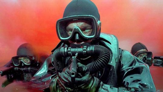 Royal Marines emerging from red smoke used as cover for an attack