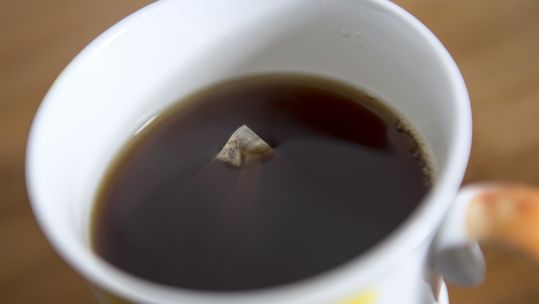 Tea bag floats in cup of tea