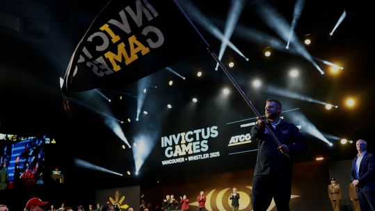 Team UK captain Stephen Hooper waves the Invictus Games flag CREDIT mod crown copyright