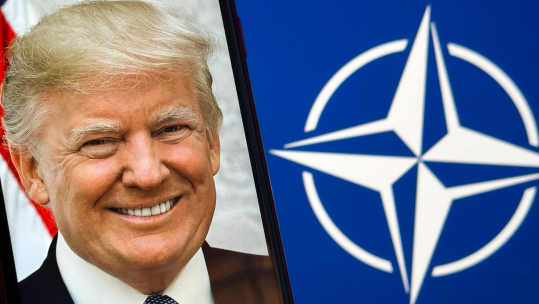 The NATO compass rose flag in the background with the official White House presidential portrait of Donald Trump Image ID 2XH4095 CREDIT ALAMY.png