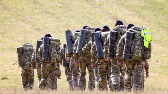 The anonymous recruits from HMS Collingwood march through a field outside Erlestoke during Exercise Hidden Dragon