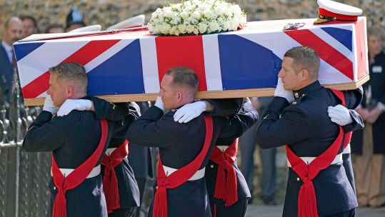 The coffin of Major General Matthew Holmes, former head of Royal Marines, is carried into Winchester Cathedral in Hampshire