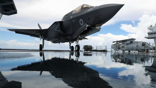 UK F-35B from 617 Squadron on board HMS Queen Elizabeth with 820 NAS Merlin in background (Picture: MOD).