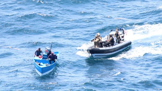 US Coast Guards, deployed from RFA Wave Knight, seizing a suspected drug trafficking vessel in international waters near South America