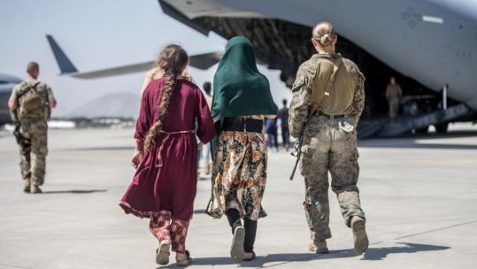 US Marine walks with evacuees at Hamid Karzai airport in Kabul Afghanistan (Picture: US Marine Corps).