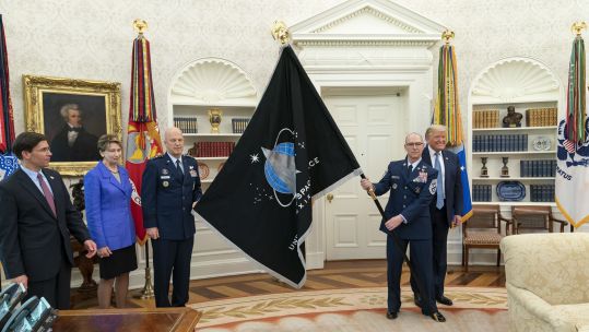 US Space Force CSO GEN Jay Raymond and US Space Force Senior Enlisted Advisor CMSgt Roger Towberman present US President Donald Trump with the US Space Force Flag (Picture: PA).
