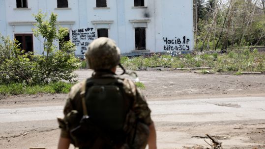 Ukrainian soldier Chasiv Yar in front of building destroyed by Russian shelling Image ID 2X7RYJ9 180524 CREDIT Ukrinform, Alamy Stock Photo