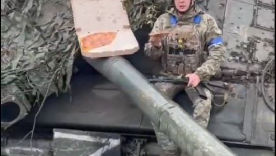  Ukranian soldier eating pizza on Russian tank CREDIT Оперативний ЗСУ
