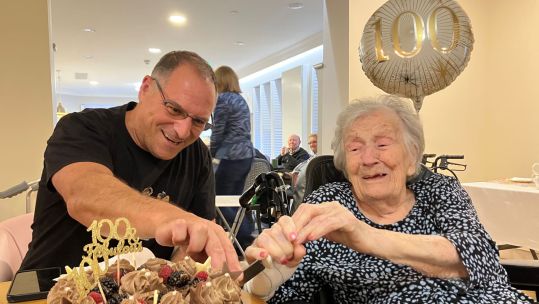 WAAF veteran Mrs Amy Wein cuts her cake with help from grandson Daniel at her 100th birthday party CREDIT Royal Star & Garter
