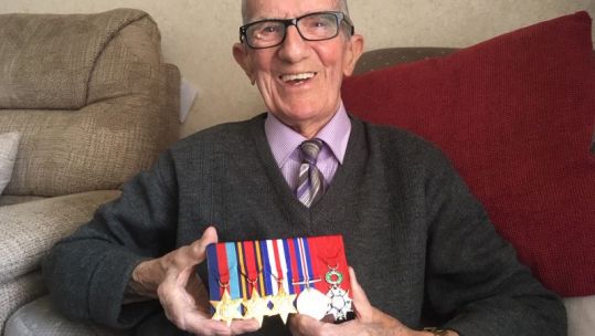 WWII Royal Marine Veteran Jim Healy holding his medals