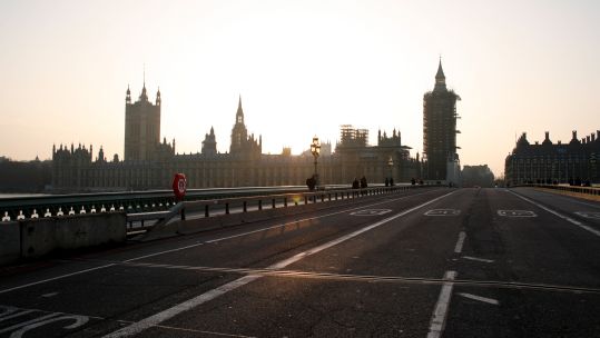 Westminster Bridge stands momentarily empty of traffic as the sun sets behind the Houses of Parliament in London, England