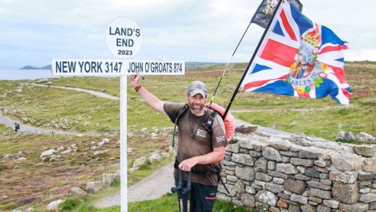 Mark Harding at Land's End sign post 25 August 2023 CREDIT Scotty's Little Soldiers