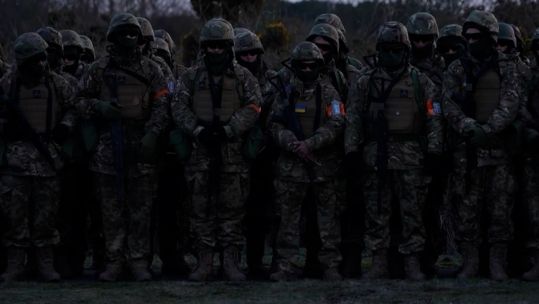 Ukrainian soldiers remember their fallen comrades on the first anniversary of the start of the war.