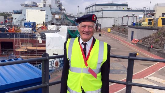 WW2 veteran Archie Hazledine on a rooftop at Scotstoun with the new HMS Glasgow behind CREDIT Royal Navy
