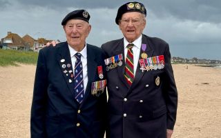 D-Day veterans Henry Rice (left) and Ken Hay MBE share a touching moment on Sword Beach (Picture: BFBS)