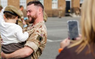 A PWRR soldier places his beret on his son's head after the parade, sharing a proud and heartfelt moment of love, family and homecoming (Picture: MOD)