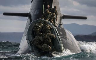 Soldiers from 148 (Meiktila) Commando Forward Observation Battery board a German submarine as they practise their float-on/float-off drills off the coast of Cape Wrath (Picture: MOD)