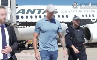 Mr Roberts‑Smith pictured at the moment of his arrest, shortly after arriving at Sydney Airport