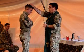 A military padre blesses a KFOR soldier during a field service in Kosovo (Picture: BFBS)