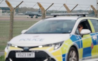 Police patrol the perimeter as a US Air Force Rockwell B-1 Lancer bomber lands at RAF Fairford in Gloucestershire (Picture: PA Images)