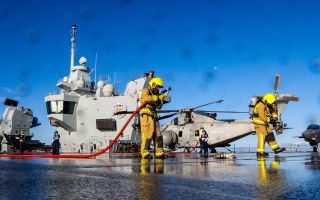 Response teams on HMS Prince of Wales conduct a crash-on-deck exercise simulating a helicopter crash on the flight deck with resulting casualties