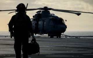 A crew member from 814 Naval Air Squadron walks out to their Merlin Mk2 on board HMS Prince of Wales during Operation Firecrest in the High North (Picture: MOD)